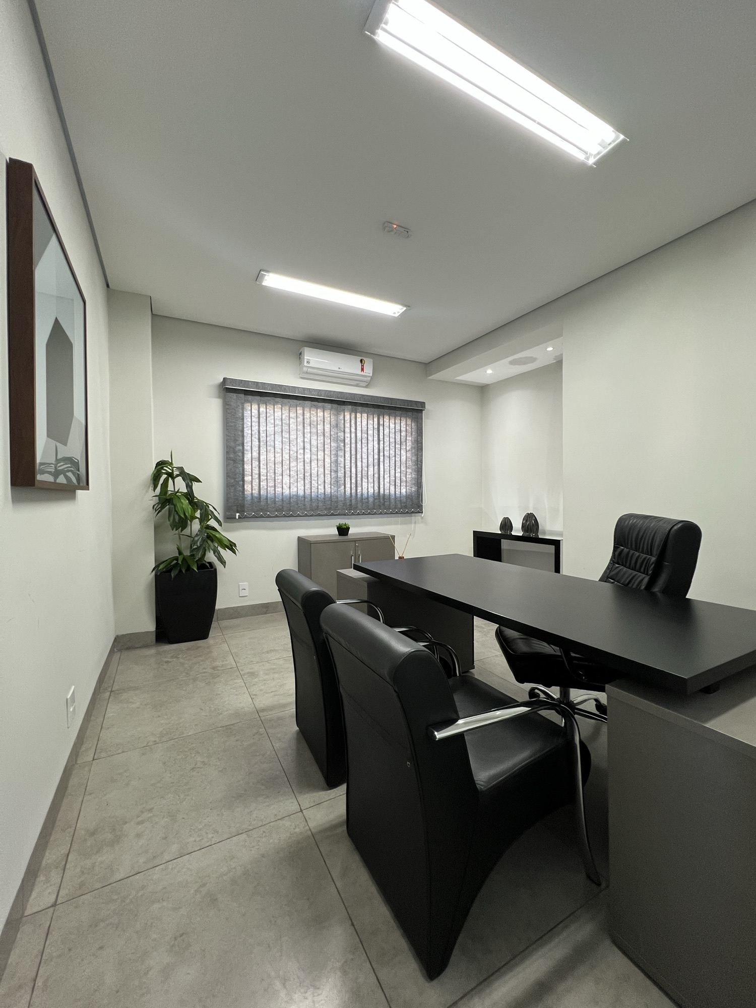 Sala de atendimento do B.office, com mesa e cadeiras de couro.